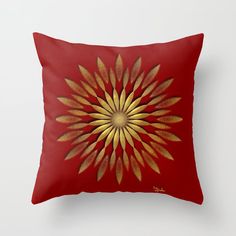 a red and gold throw pillow with an abstract flower design on the front, along with a white background