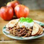 a plate with some tacos and apples in the background