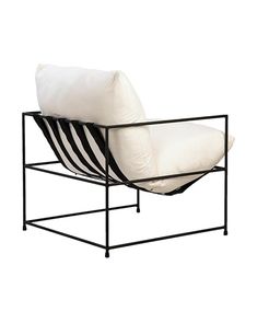 a black and white chair sitting on top of a metal frame next to a pillow