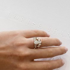 a woman's hand with a diamond ring on top of her finger and the words louis jehan written in white lettering