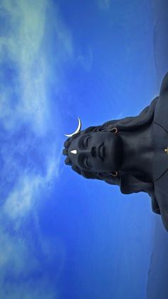 a statue of a man's head is shown against a blue sky