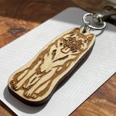 a wooden keychain with a bear carved on it's side sitting on top of a piece of paper