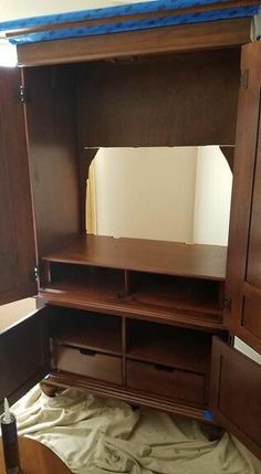 a wooden cabinet with drawers and a mirror on it's side, in the process of being painted