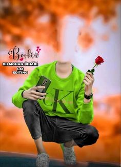 a male in a green shirt is holding a red rose and cell phone while kneeling down