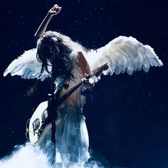 a woman with white wings holding a guitar