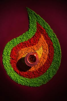 a colorful flower arrangement with a candle in the center