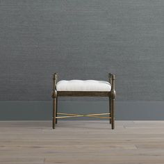 a wooden bench sitting on top of a hard wood floor next to a gray wall