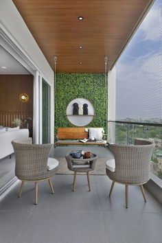 a living room filled with furniture next to a window covered in green plants and greenery