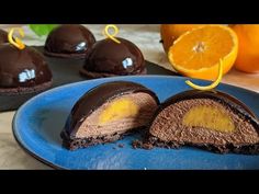 there is a chocolate dessert with oranges on the side and one half cut in half