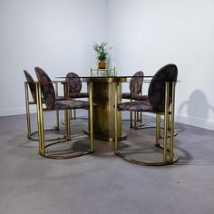 a dining table with chairs around it and a potted plant on the top shelf