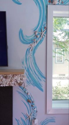 the wall is painted with blue and white waves, seashells and starfish