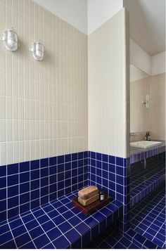 a bathroom with blue and white tiles on the walls