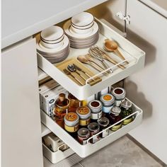 an open drawer in a kitchen filled with dishes and utensils