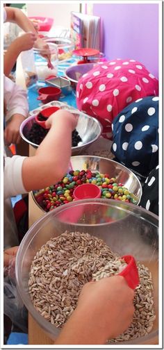 children are eating their food from bowls on the table in front of them and one child is holding a spoon