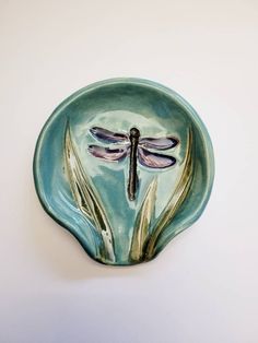 a green plate with two dragonflies on it