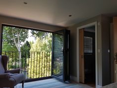 a living room with sliding glass doors leading to a balcony and trees outside the window