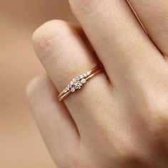 a woman's hand with a diamond ring on top of her finger, showing the side view