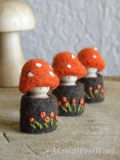 three small mushrooms sitting on top of a wooden table