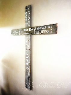 a wooden cross hanging from the side of a wall