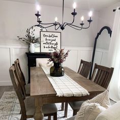 a dining room table with chairs and a vase filled with flowers sitting on top of it