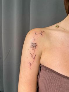 a woman with a flower tattoo on her shoulder