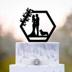 a wedding cake topper with a couple and their dog on it's side