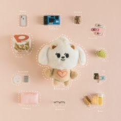 a stuffed animal surrounded by other toys and magnets on a pink background with space for text