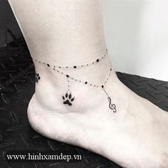 a black and white photo of a person's foot with a dog paw tattoo on it