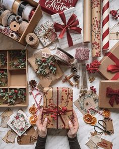 someone is wrapping christmas gifts on the table