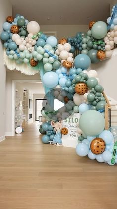 balloons are arranged in the shape of a letter on top of a wooden floor and stairs