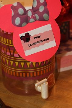 there is a pink minnie mouse pin with a name tag in the middle of it