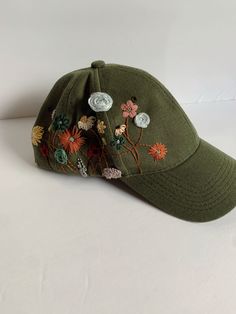 This hat has been hand embroidered in different shades of climbing flowers.   As shown in the pictures, it has a way to adjust the size of the hat to fit all heads. Green Spring Baseball Cap With Short Brim, Spring Baseball Cap With Embroidered Logo, Spring Baseball Cap With Embroidered Logo And Short Brim, Green Spring Brimmed Baseball Cap, Brimmed Hat With Floral Embroidery, Spring Hat With Embroidered Logo And Short Brim, Adjustable Baseball Cap With Floral Embroidery, Floral Embroidered Brimmed Hat, One Size, Adjustable Snapback Hat With Floral Embroidery