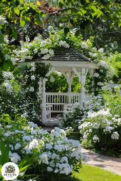 a gazebo surrounded by white flowers and greenery