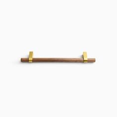 a wooden and brass handle on a white wall