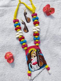 a necklace and earring set on a white tablecloth with flowers in the background