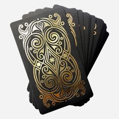 four black and gold playing cards with intricate designs