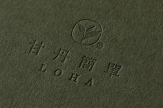 a close up view of the logo on a green surface with chinese characters and words