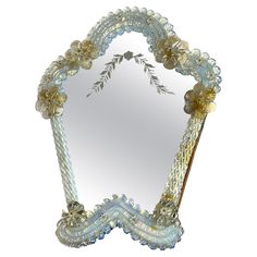 a decorative mirror with flowers and leaves on the edge is shown against a white background