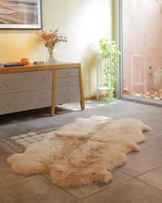 a white rug sitting on top of a floor next to a dresser