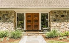 a stone house with two wooden front doors