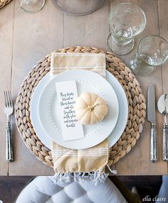 a place setting with white plates, silverware and napkins on a wooden table