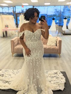 a woman is taking a selfie in her wedding dress at the bridal shop