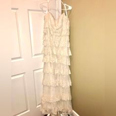 a white dress hanging on a hanger in front of a door