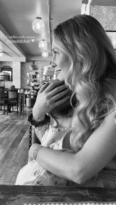 black and white photograph of a woman sitting at a table with her hands on her face