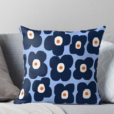 a blue and white flower pillow sitting on top of a couch