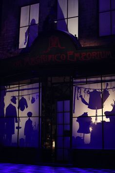 the silhouettes of people are projected on windows in front of a building at night