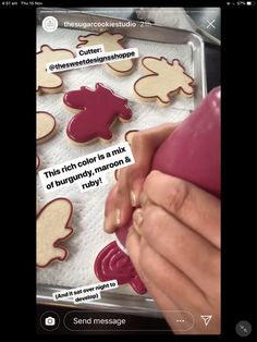 someone is decorating some cookies with red icing