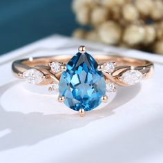 a blue and white diamond ring sitting on top of a table