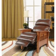 a brown recliner chair sitting on top of a rug in front of a window