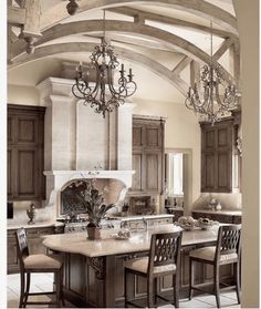 a large kitchen with an island and chandelier hanging from it's ceiling